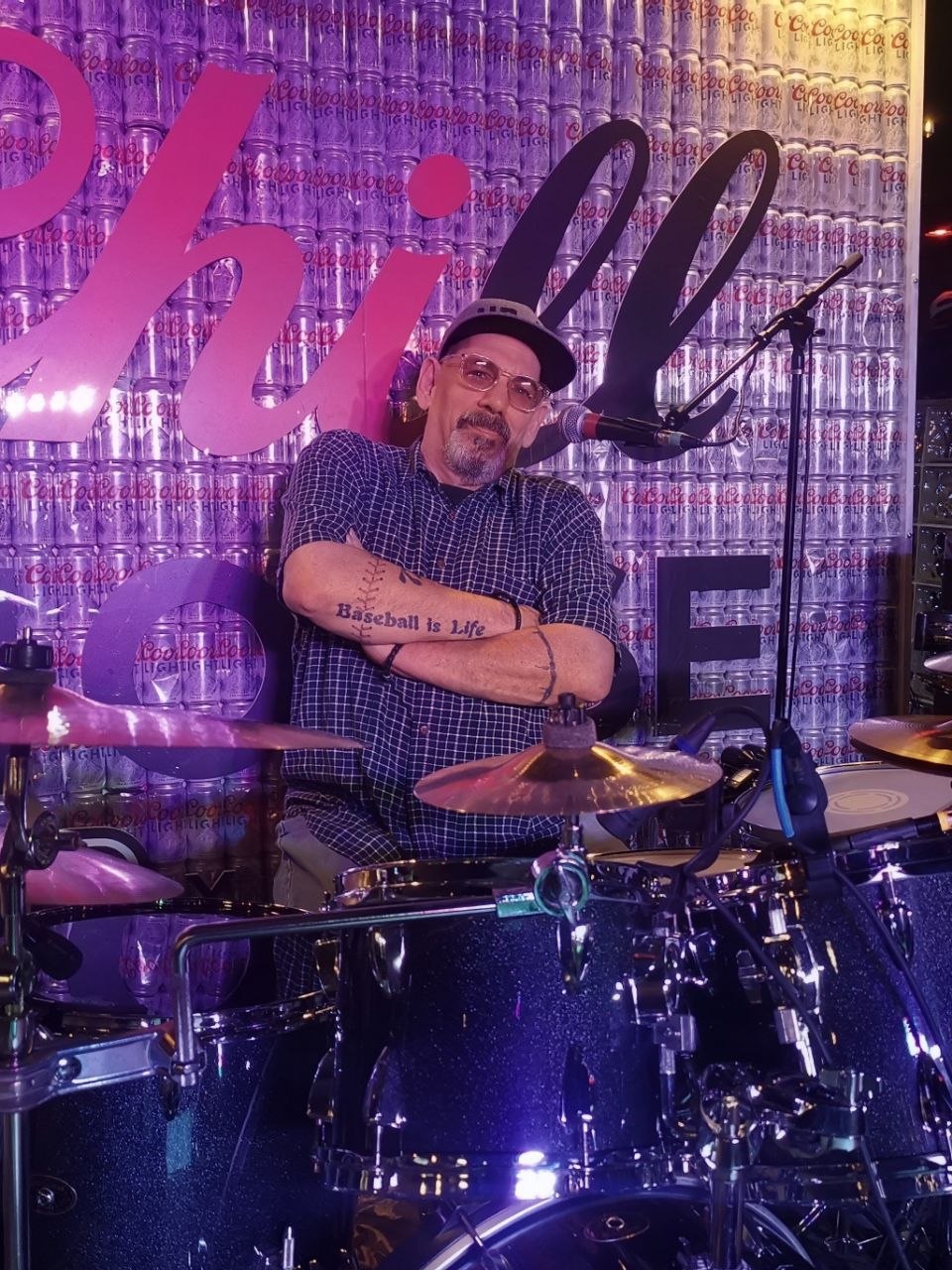 Jim 'Crash' Mihalovich at his drum kit under blue stage lighting